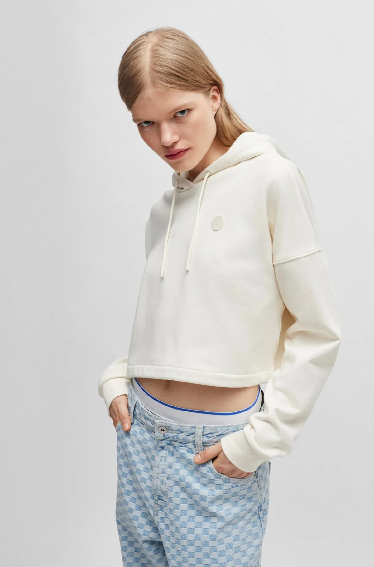 afkortet_httetrje_i_bomuldsfrott_med_happy_hugo_logobadge_1-1.webp HUGO BOSS Afkortet Hættetrøje I Bomuldsfrotté Med Happy HUGO Logobadge Naturlig Fashion